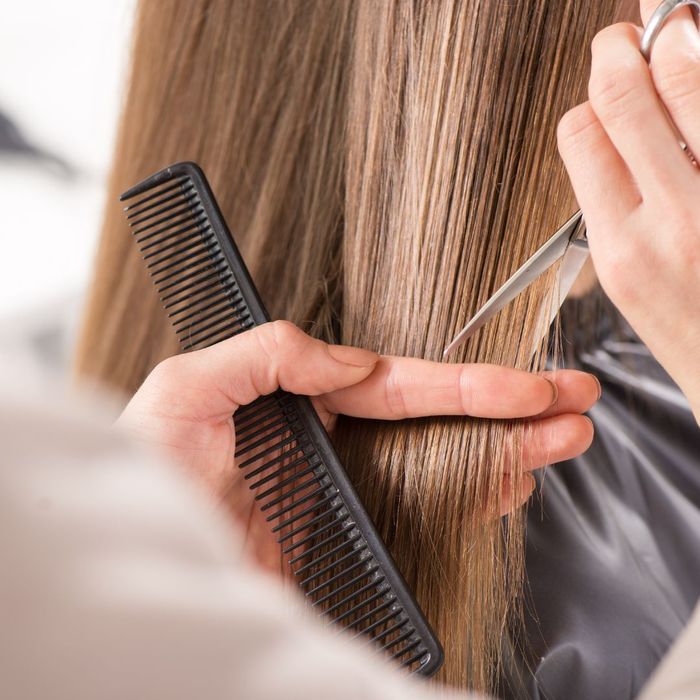 Hair stylist cutting layers into hair