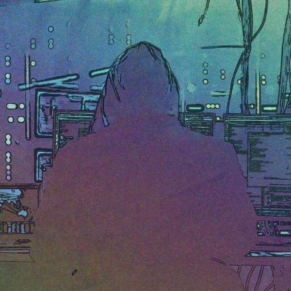 hooded figure in front of a computer desk setup hooded figure in front of a computer desk setup