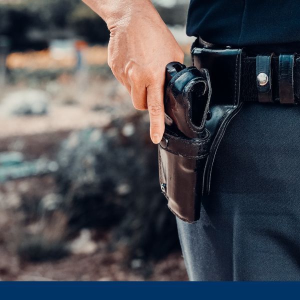 Close up of a security guard's hand on his firearm holster