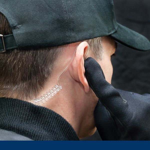 security detail holding a finger up to earpiece security detail holding a finger up to earpiece