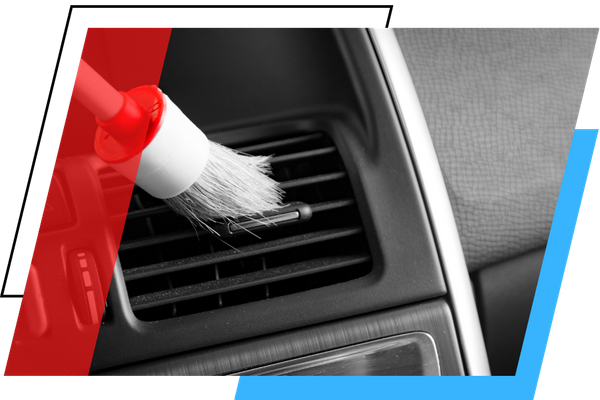 cleaning an air vent with a brush