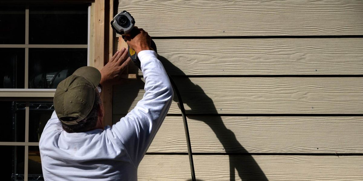 person installing house siding