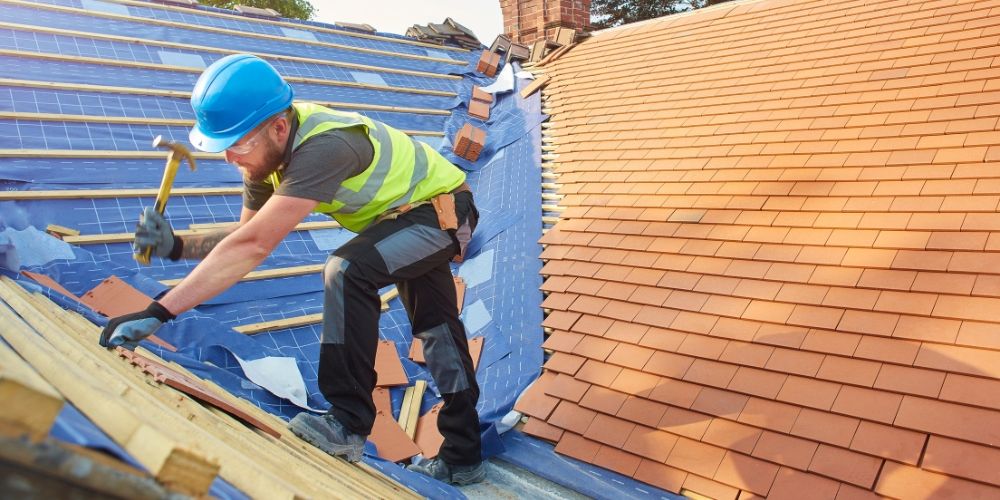 A roofer replacing a roof