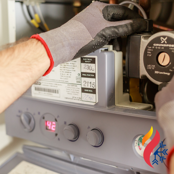 An HVAC tech working on the base of a water heater