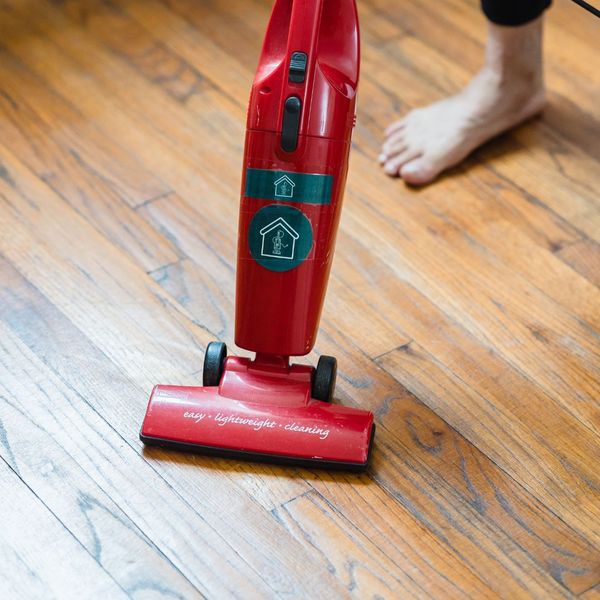 a person using a red vacuum a person using a red vacuum