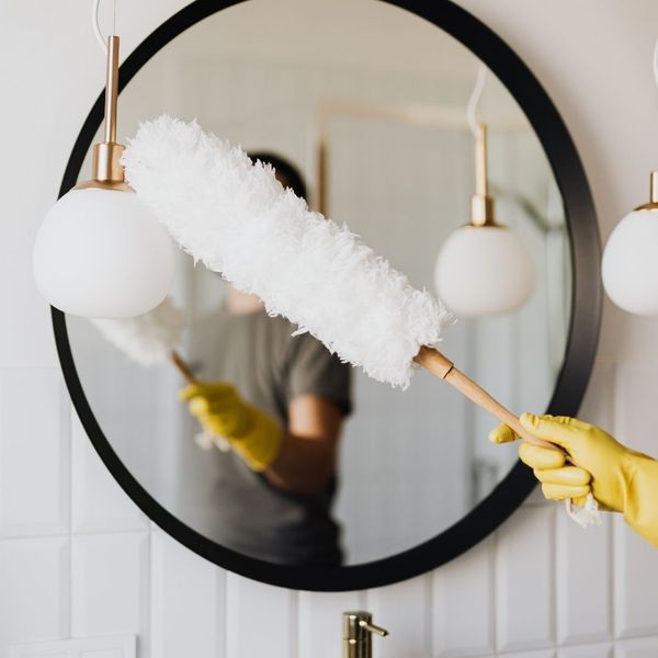 person dusting a mirror