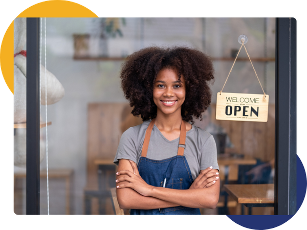 business owner smiling in front of open sign