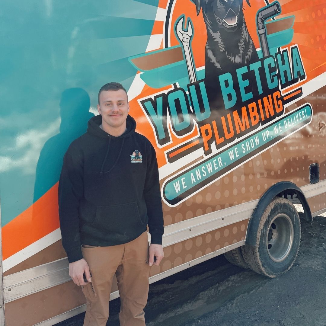 friendly plumber next to service truck friendly plumber next to service truck