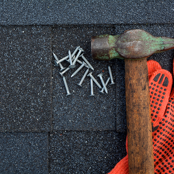 hammer and nails on shingle roof