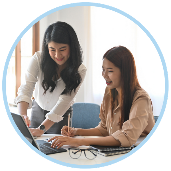 two women leaning over a laptop. 