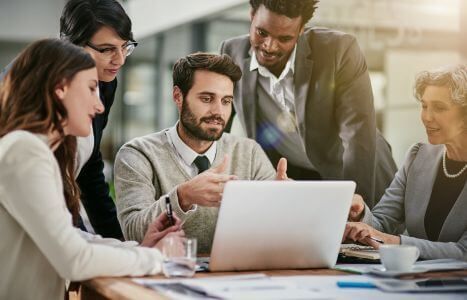 employees sitting around laptop