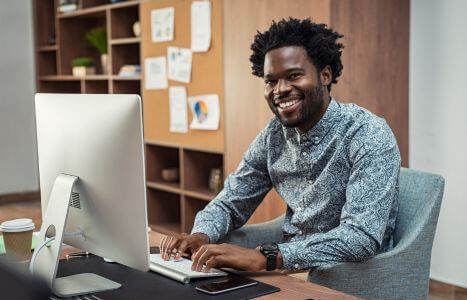 man smiling while using computer