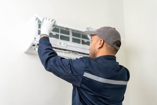 HVAC tech performing AC maintenance 