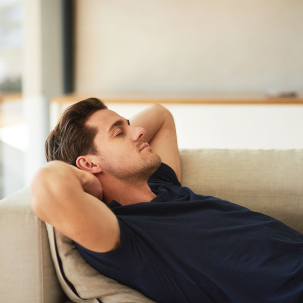 man relaxing on couch with his eyes closed