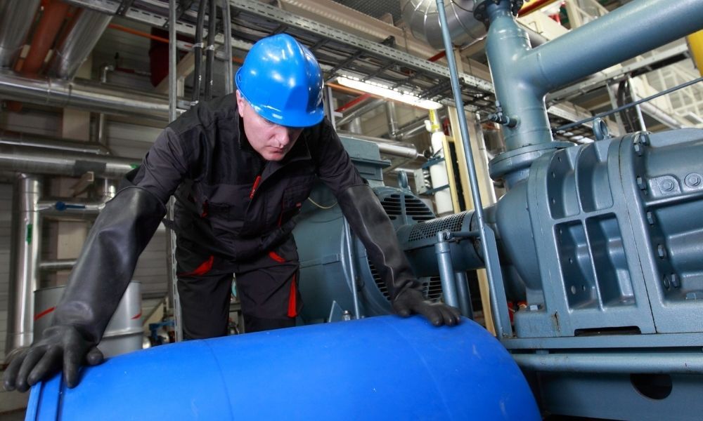 worker in factory rolling large barrel