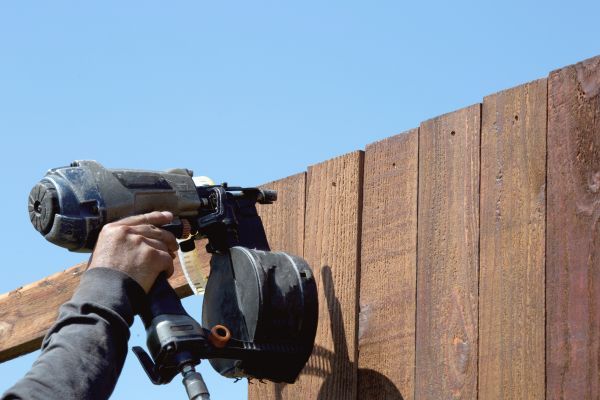 nailing boards on a wood fence