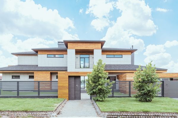 modern house with slatted privacy fence and gate for front yard