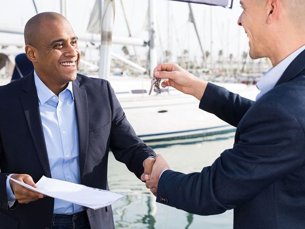 broker handing keys to new boat owner