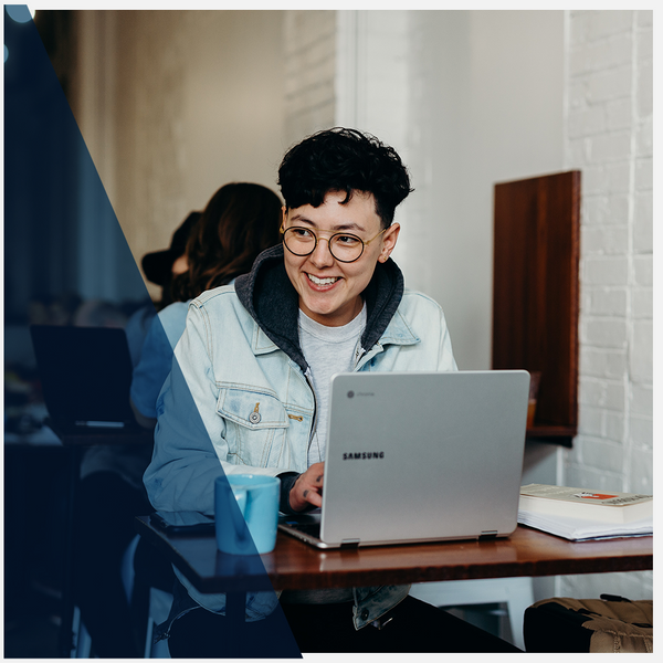 person smiling at their laptop
