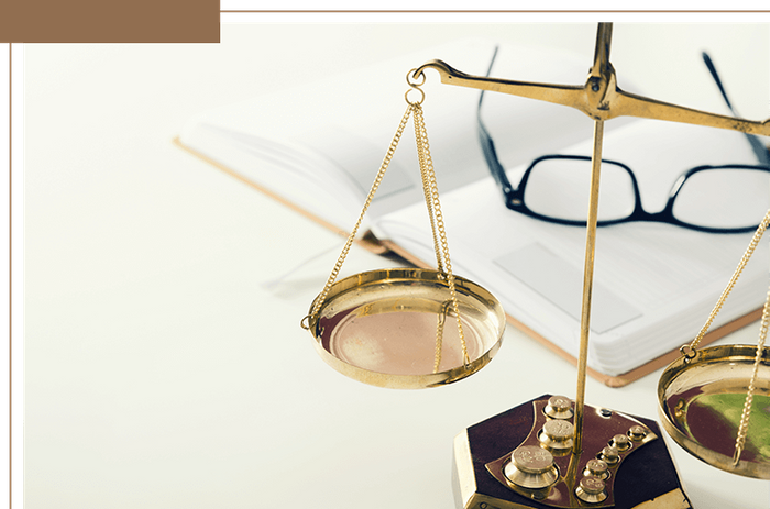 judicial scales near eyeglasses and open book