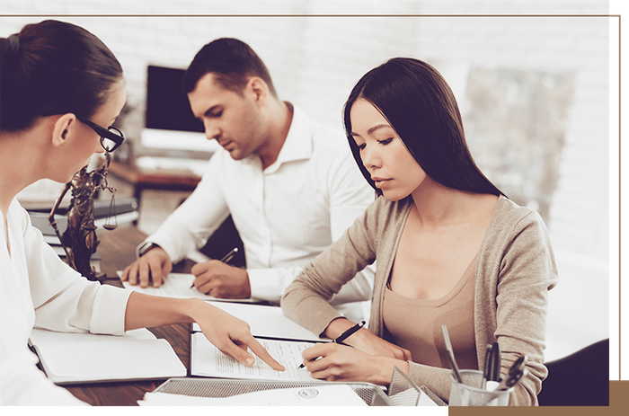 two people signing paperwork in a law office