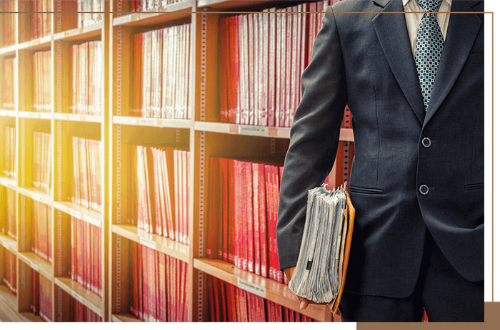 a lawyer standing in front of rows of case books