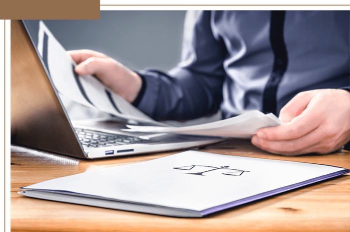 a lawyer looking at paperwork in front of a computer