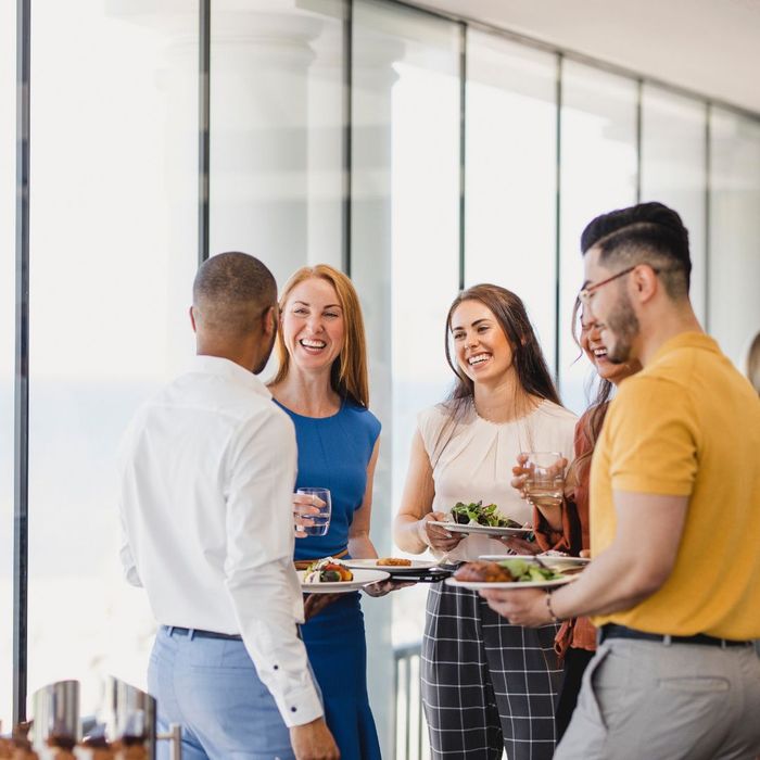 employees talking while holding healthy meals