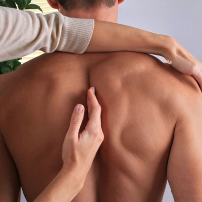 Chiropractor placing their hand on the spine of a patient