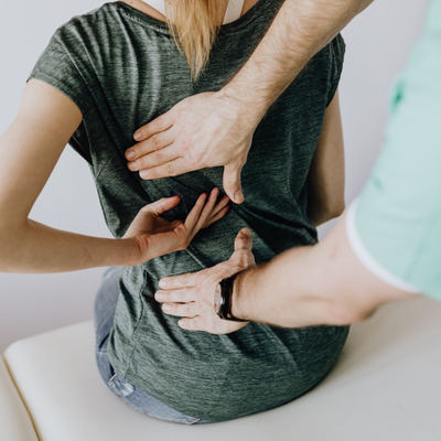 Chiropractor placing hands on woman's back