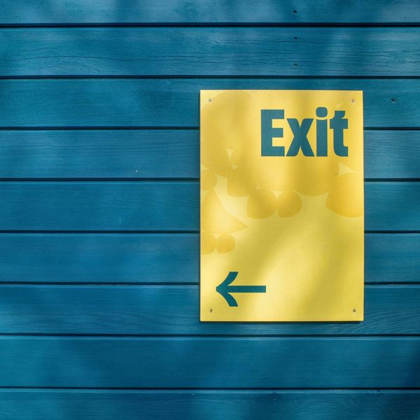 Yellow exit sign on blue background A Guide to Elevating Customer Journeys with Custom Wayfinding Signs-3.jpg