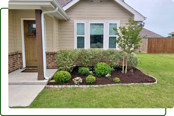a landscape bed in the front of a home with new plantings