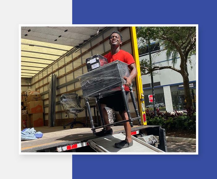 Noya team member smiling while loading furniture on truck