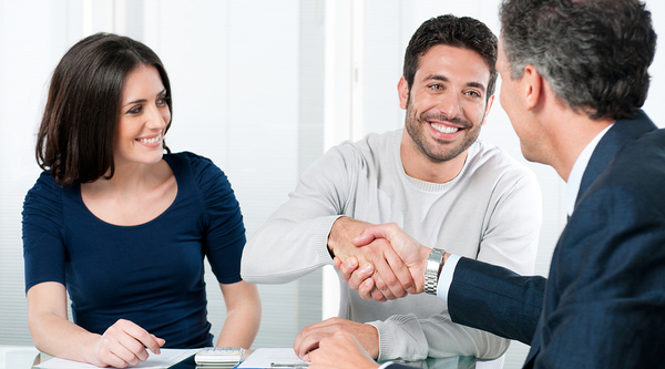 A couple shaking hands with a lawyer