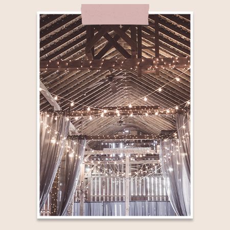 a barn venue with hanging lights and drapes