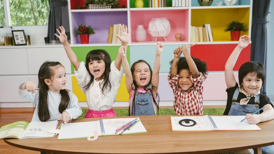 daycare students raising their hands 