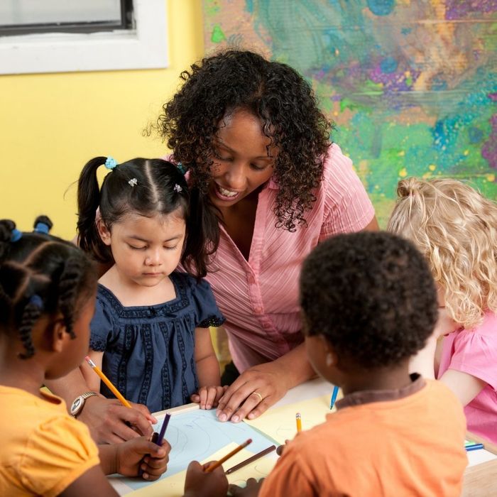 teacher working with four young students