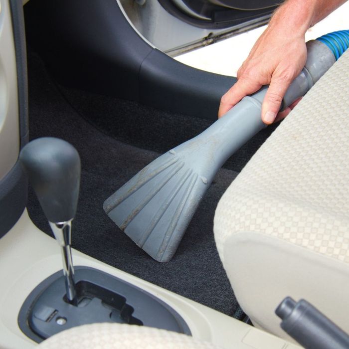 using a vacuum on the car's floor