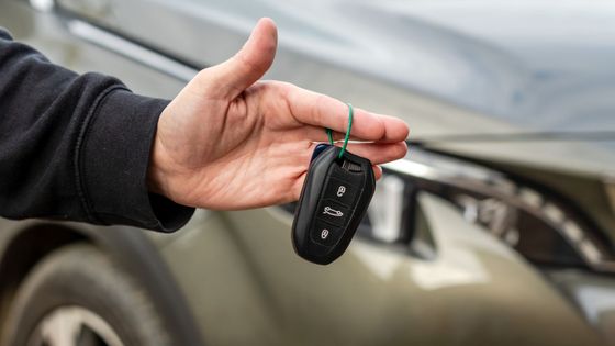 person handing car keys to a buyer