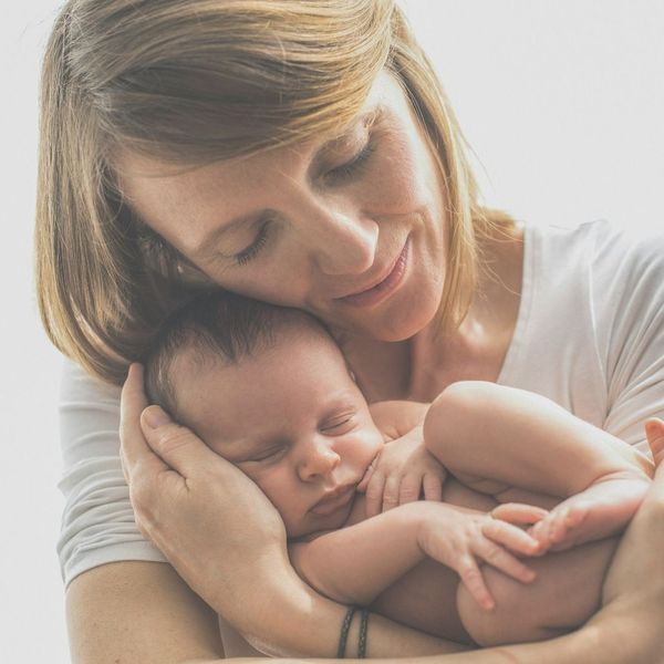 woman cuddling newborn