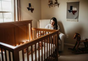 Mother watching her sleeping baby in a Texas themed nursery