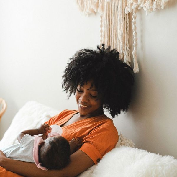 A women feeding a baby a bottle.