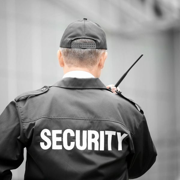 back of a security guard using a radio