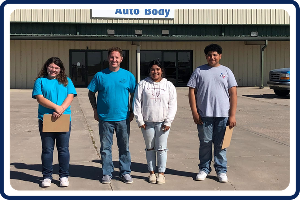 youth in front of an auto business
