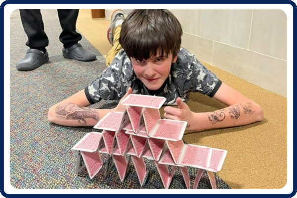child building a tower with cards