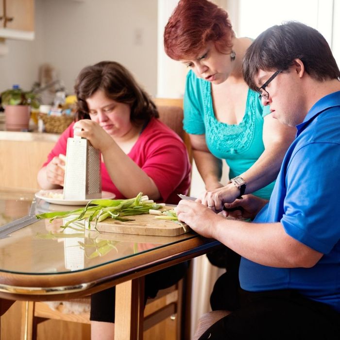 caregiver helping adult with special needs make recipe