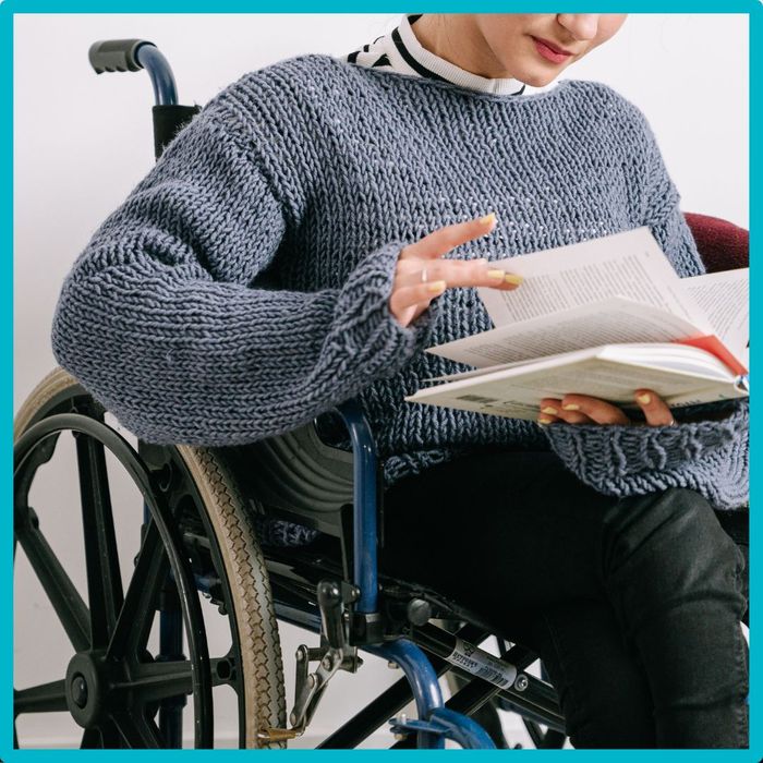 person in wheelchair reading