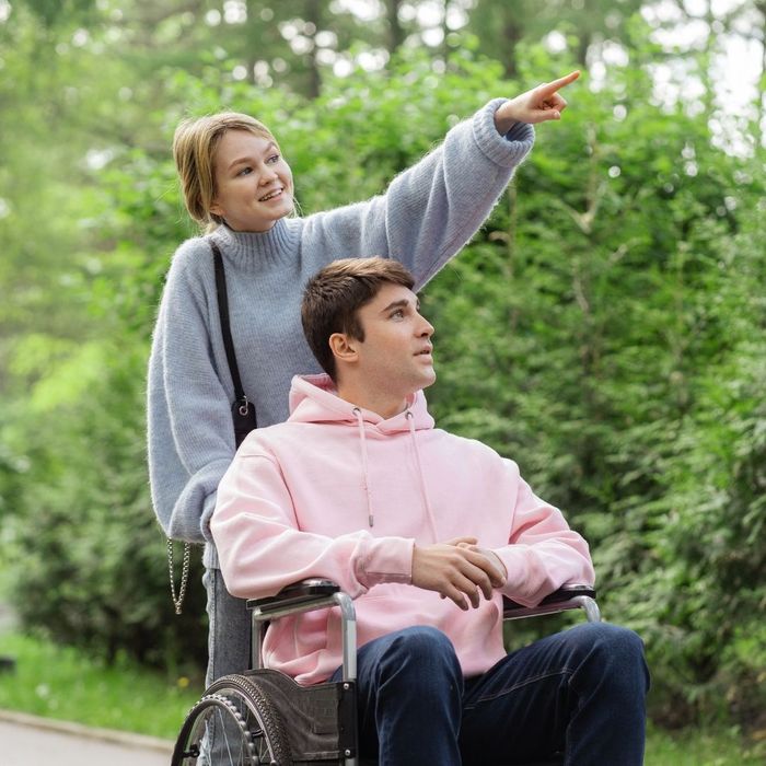 woman pointing while helping her disabled family member in wheelchair