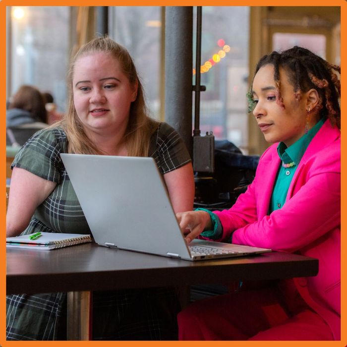 two women talking with laptop