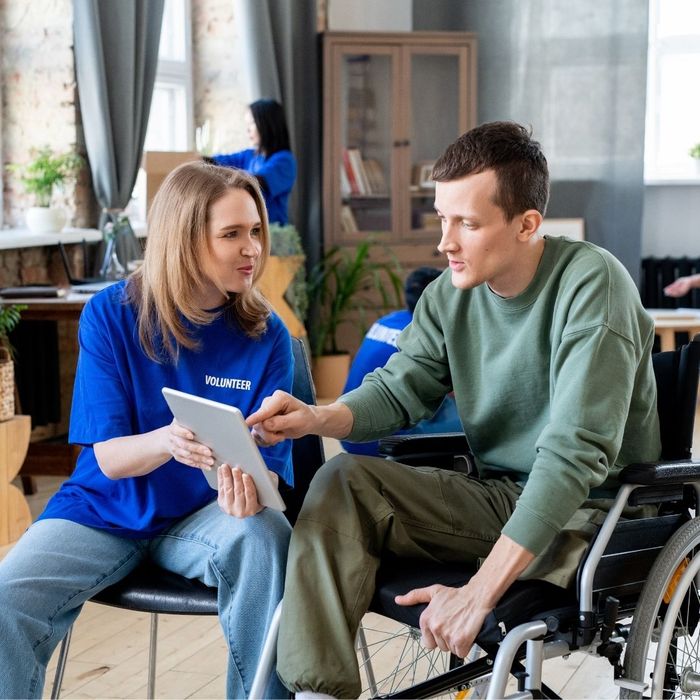 caregiver helping man in wheelchair